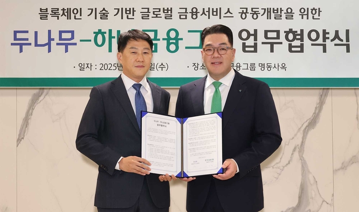 오경석 두나무 대표(왼쪽)와 이은형 하나금융그룹 부회장이 4일 서울 중구 하나금융그룹 명동사옥에서 블록체인 기반 글로벌 금융 서비스 공동개발을 위한 업무협약을 체결한 뒤 기념촬영을 하고 있다. 양사는 내년 1분기까지 블록체인 기술을 활용한 해외 송금 시스템을 구축하기로 했다. [사진=두나무]